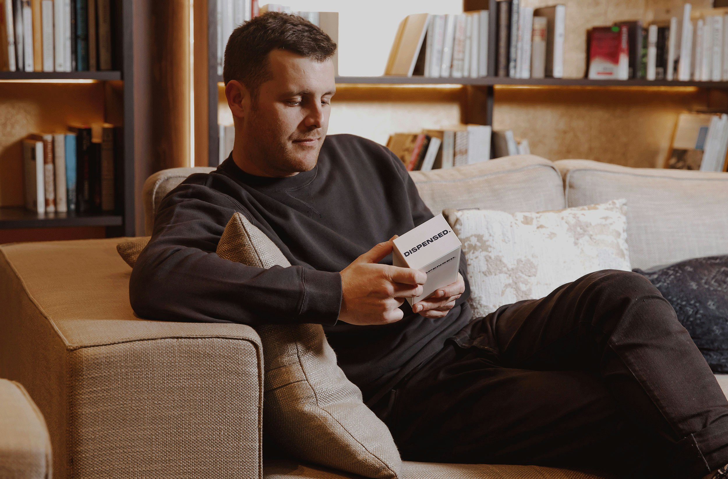 A person on a couch with a white box